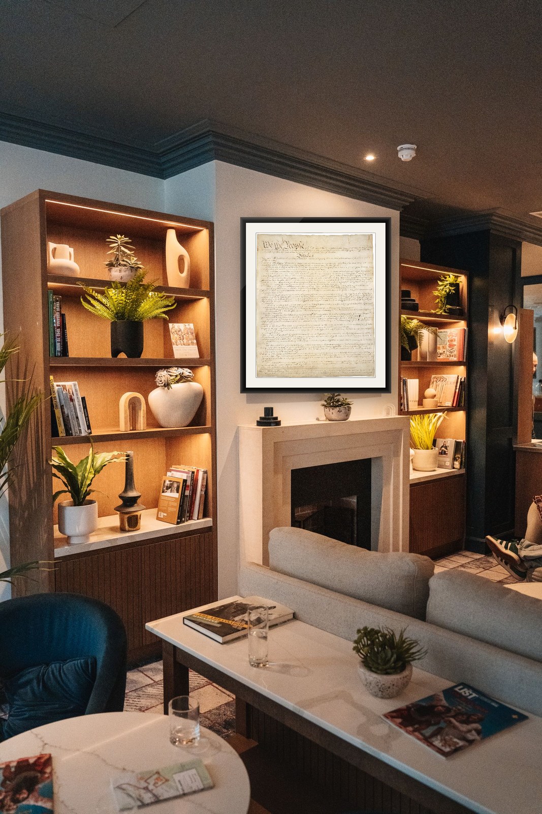 The framed United States Constitution above a fireplace in a members' club